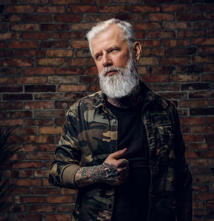 Stylish grandfather with tattooed body dressed in camouflage jacketの写真素材