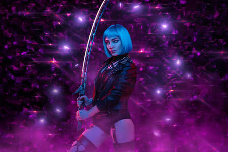 Sexy cyberpunk woman with sword posing against violet backgroundの写真素材