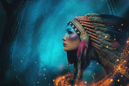 Woman in western indian style against blue forest backgroundの写真素材