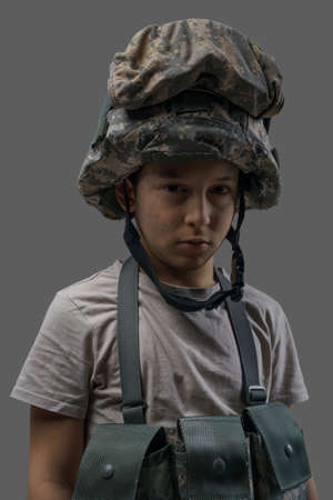 Preschool military kid with camoflage helmet and vestの写真素材