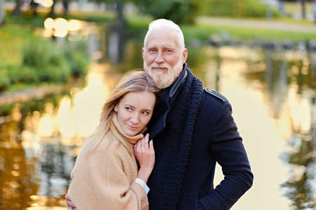 Senior man and his granddaughter in peaceful autumnal forest