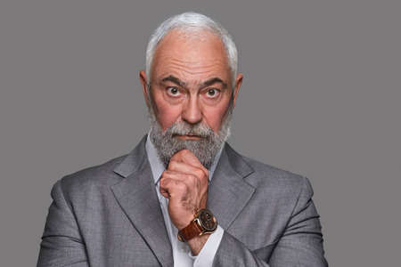Pensive old man with his hand under his chin