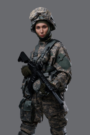 Military woman with rifle dressed in camouflage suitの写真素材