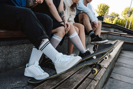Shot of hipster group people with skateboards outdoors