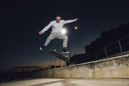 Skateboarder showing some stunts at skatepark at night timeの写真素材