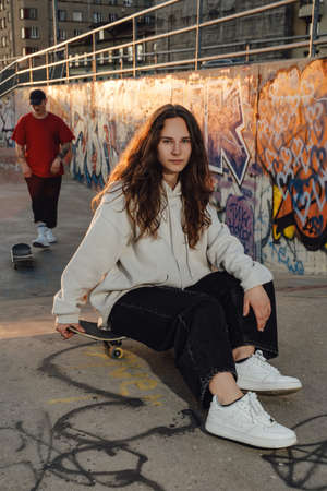 Woman skater with curly hairs at skate park outdoorsの写真素材