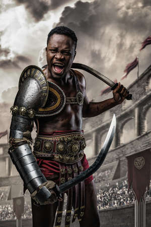 Furious roman gladiator of african ethnic with two swordsの写真素材