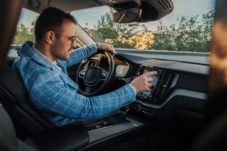 Businessman pushing button panel of car in city streetの写真素材