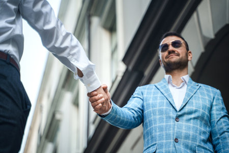 Handshake of two business partners outdoors in modern cityの写真素材