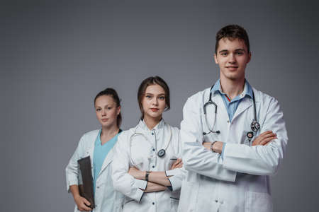 Medical team of three people looking at camera togetherの写真素材