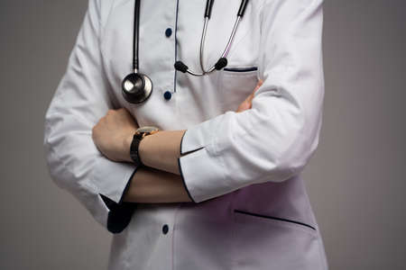 Confident doctor woman with crossed arms against grey backgroundの写真素材