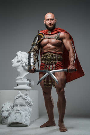 Ancient roman warrior with swords around marble statuesの写真素材