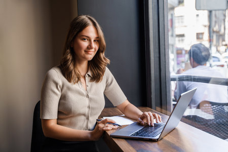Joyful businesswoman with laptop relaxing in coffee shopの写真素材