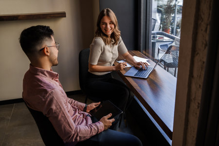Man with his girlfriend with laptop in coffee bar