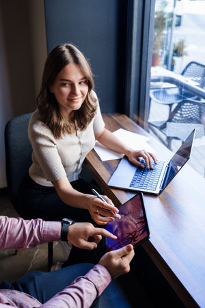 Young woman with laptop and tablet in coffee shopの写真素材