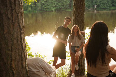 Portrait of four hikers talking and relaxing in forest tripの写真素材