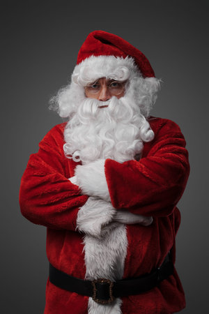 Santa with red costume posing against gray backgroundの写真素材