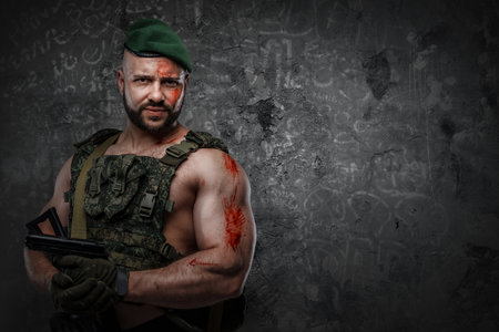 Strong military man with pistol against dark backgroundの写真素材
