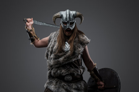 Violent viking with sword against grey backgroundの写真素材