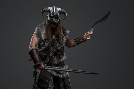 Viking from past with fur and paired swordsの写真素材