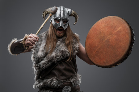 Long haired viking drummer from past with horned helmetの写真素材