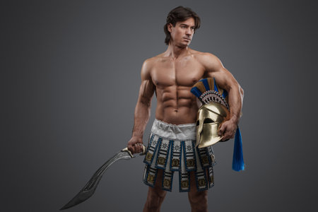 Strong swordsman from antique greece against grey backgroundの写真素材