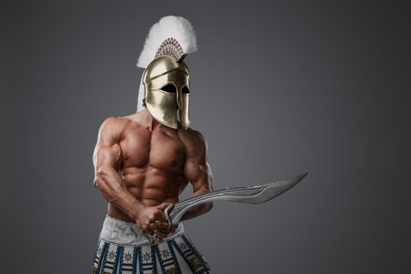 Handsome warrior with short sword against gray backgroundの写真素材
