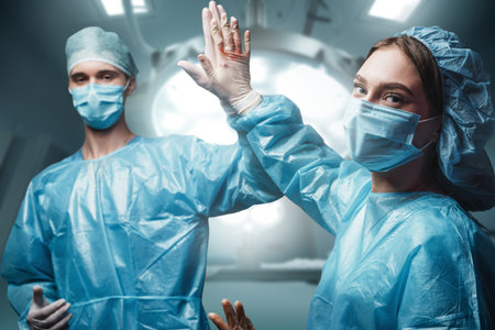 Two surgeons high five each other after successful operationの写真素材