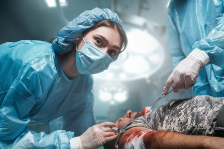 Injured soldier being treating by two surgeons in operating roomの写真素材