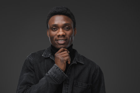 Trendy african man looking at camera against grey backgroundの写真素材