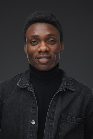 Trendy african man looking at camera against grey backgroundの写真素材