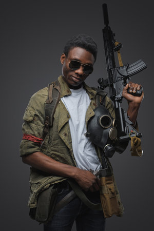 Somali pirate with sunglasses and rifle against gray backgroundの写真素材