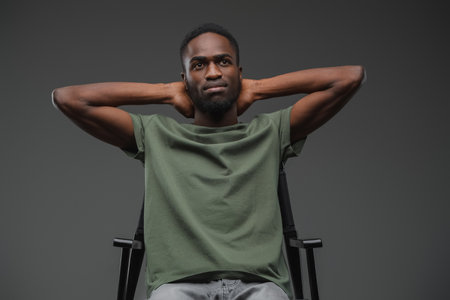 African man dressed in casual attire sitting on chairの写真素材