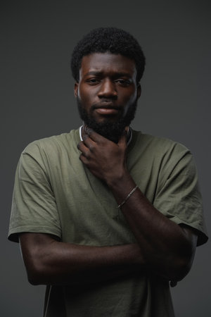 Black guy with crossed arms against grey backgroundの写真素材