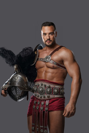 Gladiator in lightweight historical armor against grey studio backgroundの写真素材