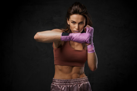 Athlete woman in sportswear, demonstrating boxing skills with hand wrapsの写真素材