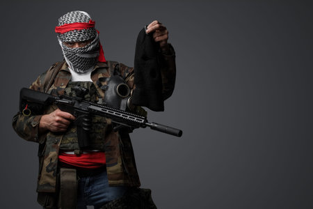 Middle east militant, camouflage uniform with black balaclava in hand