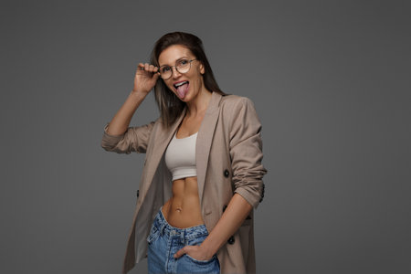 Joyful and stylish woman in sports bra and blazerの写真素材