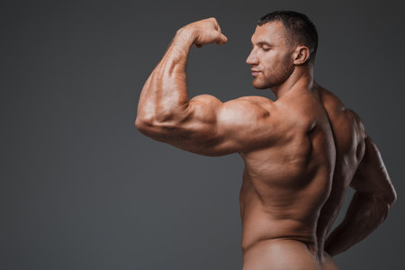 Muscular Man with Tense Muscles on Gray Backgroundの写真素材