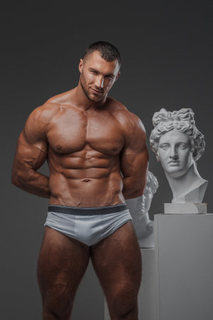 Muscular Beauty: Man and Ancient Greek Statuesの写真素材