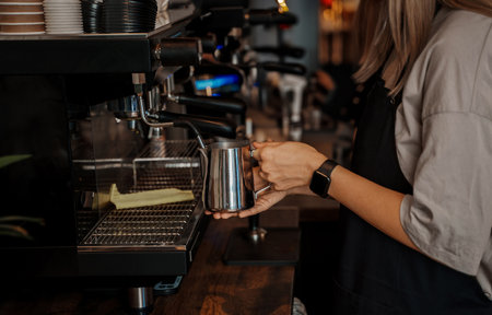 Barista Pouring Milk into Coffee Cupの写真素材