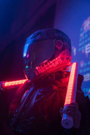 Woman in Futuristic Tactical Black Suit and Motorcycle Helmet with Neon Lampsの写真素材