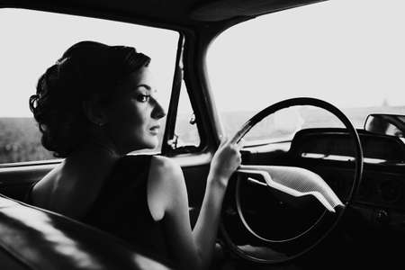 Beautiful lady sitting in a retro carの写真素材