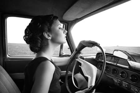 Beautiful lady sitting in a retro carの写真素材