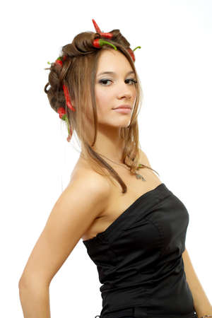 portrait of a young sexy woman with creative hair style with red hot chili peppers in her hair isolated on whiteの写真素材
