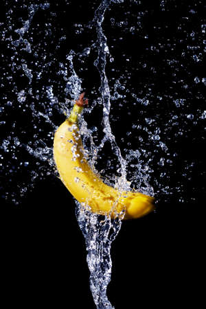 fresh banana gets hit by a water streamの写真素材