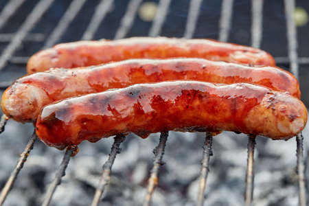 Closeup BBQ with fiery sausages on the grillの写真素材