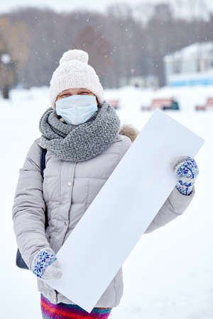 Epidemic of the Chinese coronavirus. A woman in a protective mask with a boardの写真素材