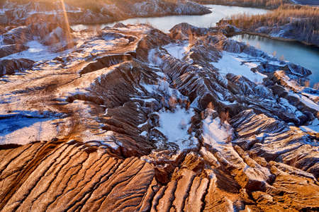 areal view sandy hills lakes rivers terrain old sand mines covered with first snow late autumnの写真素材