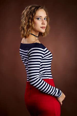 studio portrait of a young adult woman on brown backgroundの写真素材